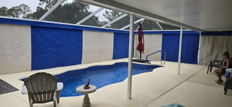 Blue and white Sunbrella privacy curtains around Fort Myers pool enclosure