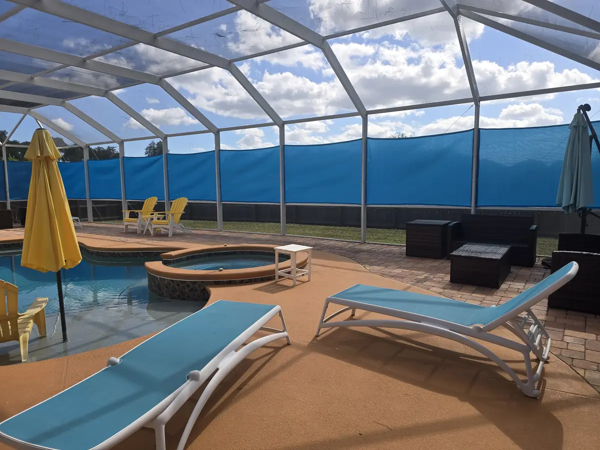 High-density mesh privacy panels with lounge seating in Fort Myers pool enclosure