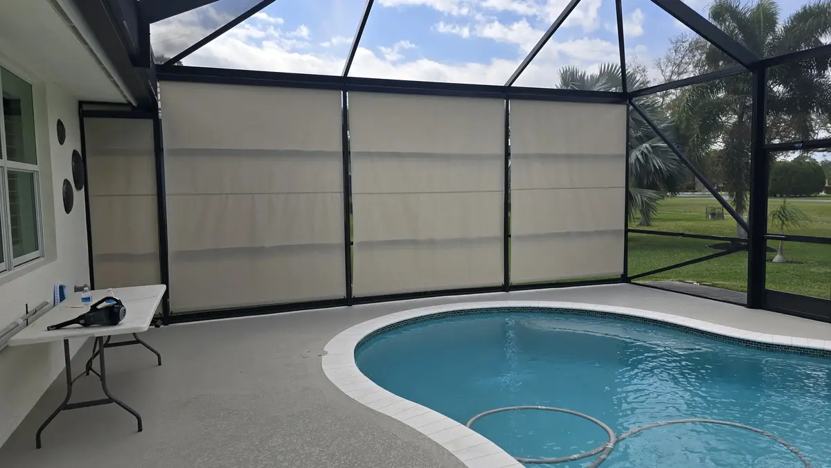 Beige UV-filtering outdoor roller shades fitted in Southwest Florida pool enclosure