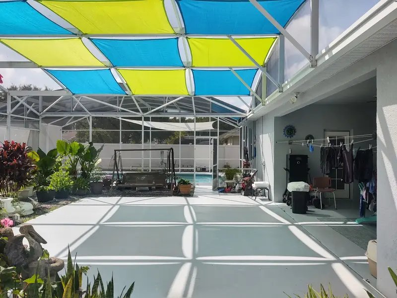 HDPE shade sail panels providing overhead coverage in Fort Myers pool enclosure
